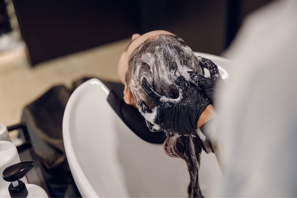 close-up-of-female-barber-washes-the-hair-of-woman-2025-03-26-05-09-16-utc_Medium